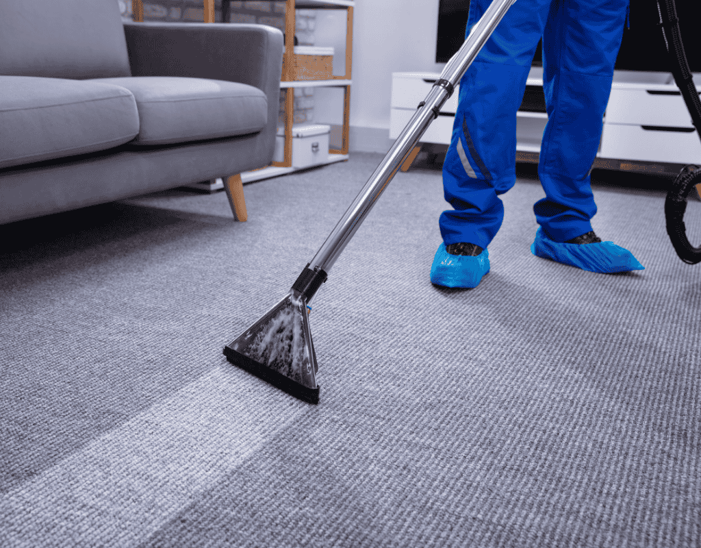 Professional cleaner extracting dirt from carpet during standard house cleaning service in Greater Houston