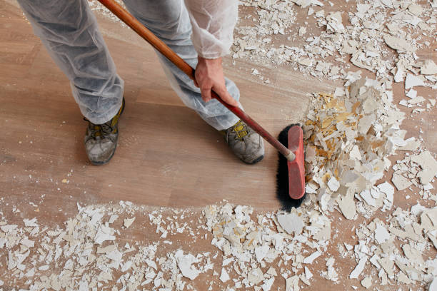 Professional cleaner wiping glass surface to remove construction dust during post construction cleaning